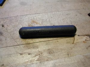 The piece of ebony is turned to a dowel and cut with a radius cutter at the butt end.