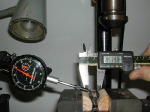 Positioning the frog in the milling vise using the dial indicator and the vernier calipers.